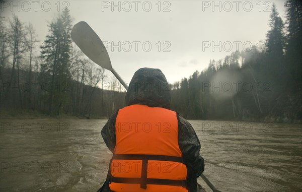 Mari man kayaking on river