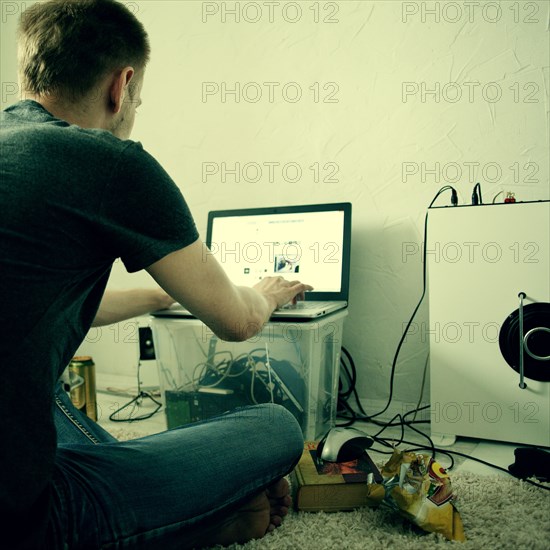 Caucasian man using laptop on floor