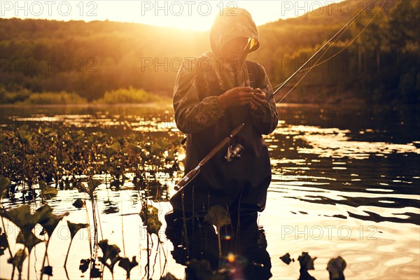 Mari fisherman preparing hook in lake