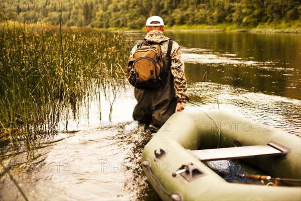 Mari fisherman pulling boat through lake