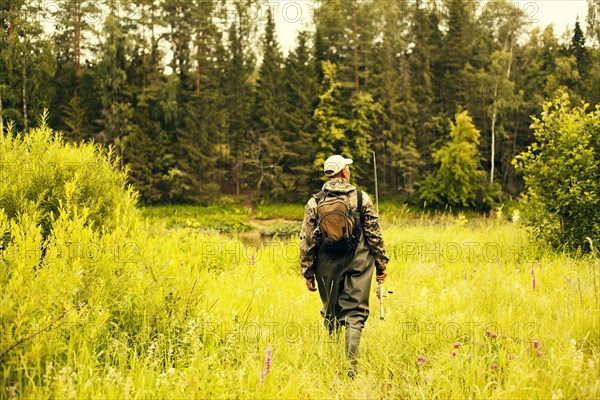 Mari fisherman walking through field