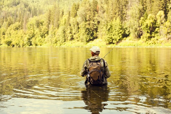 Mari fisherman holding fishing rod in lake