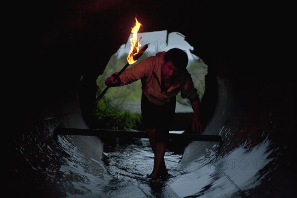 Mari man holding torch in tunnel