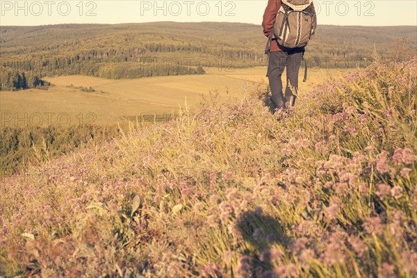 Mari man carrying backpack in rural field