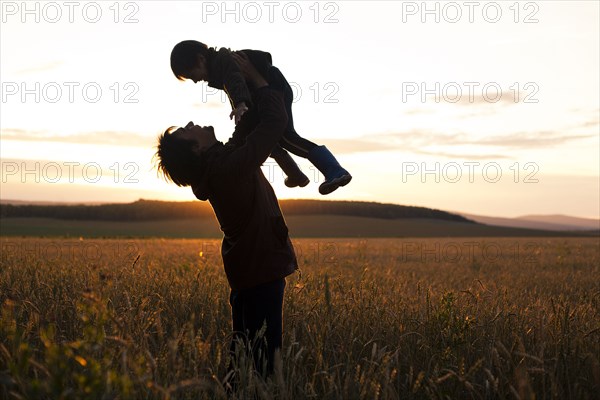 Mari father and son playing in rural field