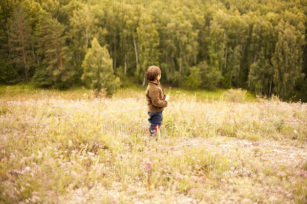 Mixed race boy standing in rural field