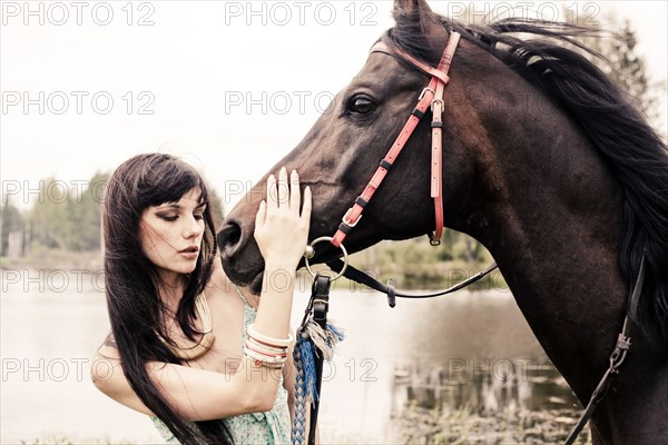 Caucasian woman petting horse outdoors