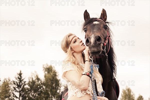 Caucasian woman petting horse outdoors