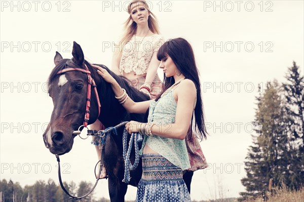 Caucasian women petting and riding horse outdoors