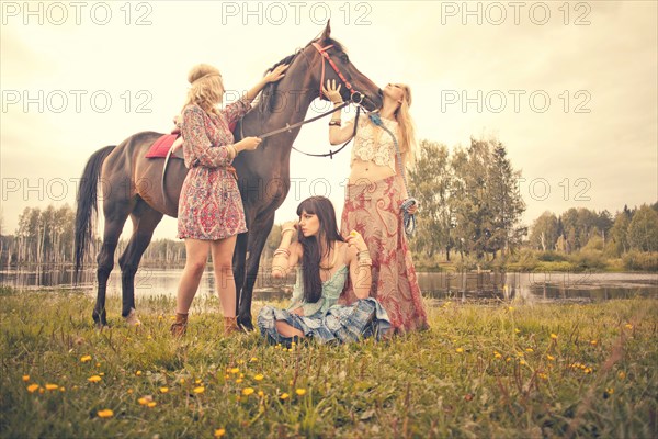 Caucasian women petting horse in rural field