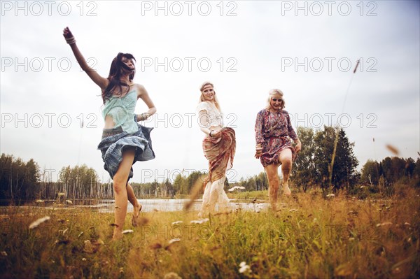 Caucasian women playing in field near lake