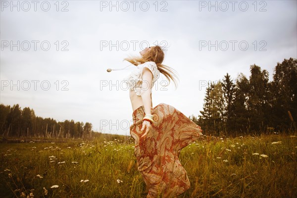 Caucasian woman dancing in field