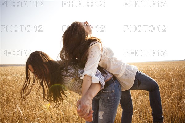 Caucasian women playing in rural field