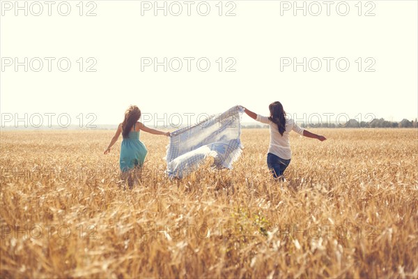 Caucasian women carrying blanket in rural field