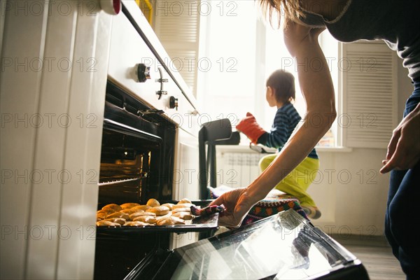 Mother and son baking cookies in kitchen