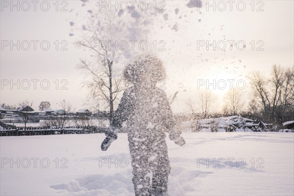 Mari boy in parka playing in snowy field