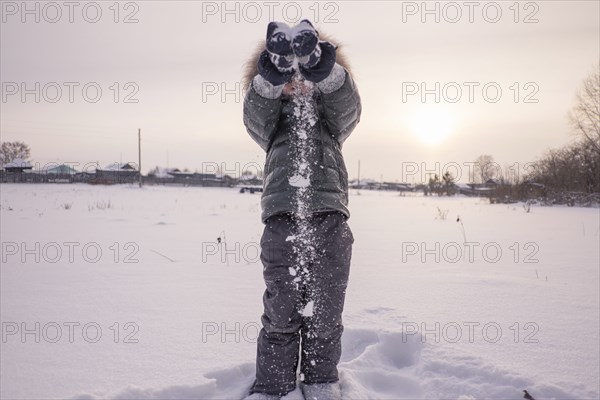 Mari boy in parka playing in snowy field