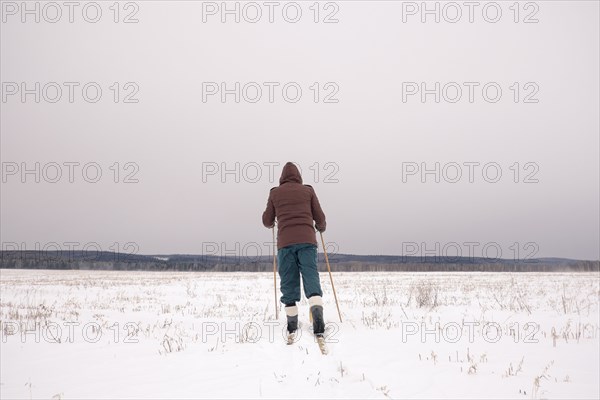 Woman cross-country skiing in snowy field