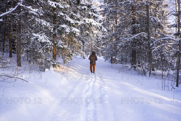 Mari boy walking in snowy field