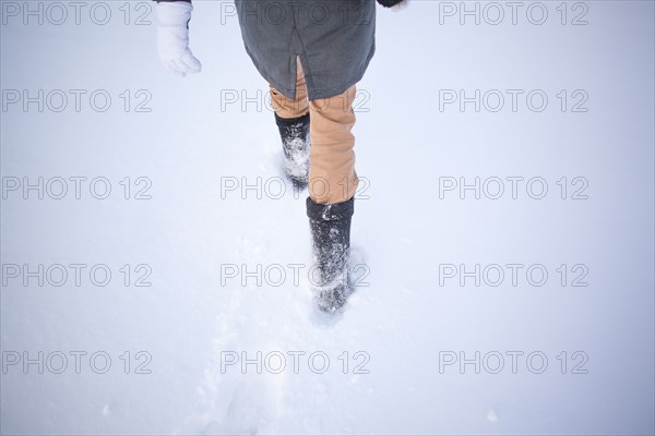 High angle view of Caucasian woman walking in snowy field