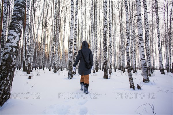 Caucasian woman walking in snowy forest