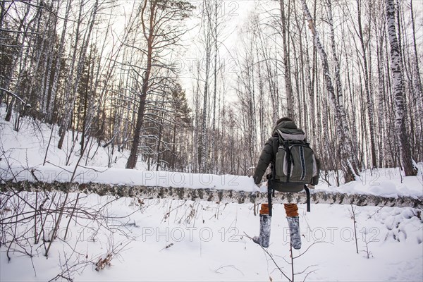 Mixed race man walking in snowy forest