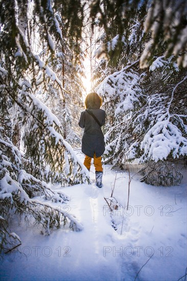 Caucasian woman walking in snowy forest