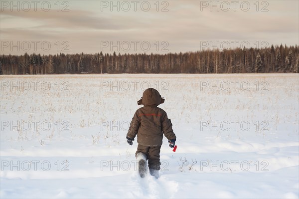 Mari boy walking in snowy field