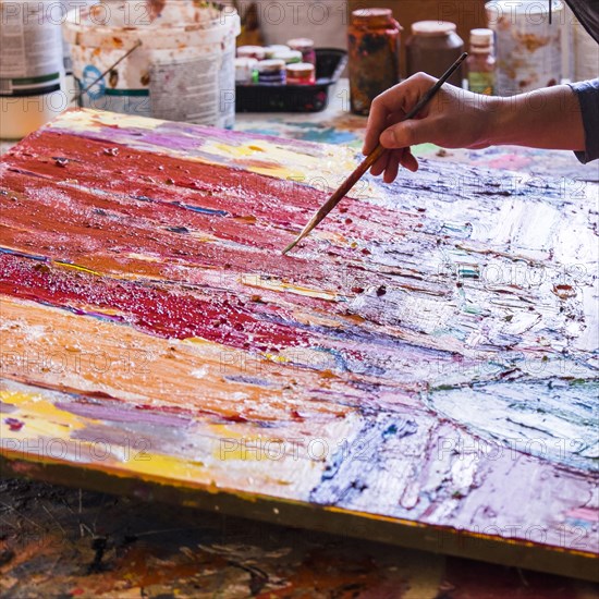 Mari artist painting canvas in studio