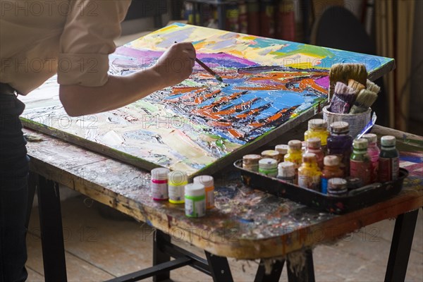 Mari artist painting canvas in studio