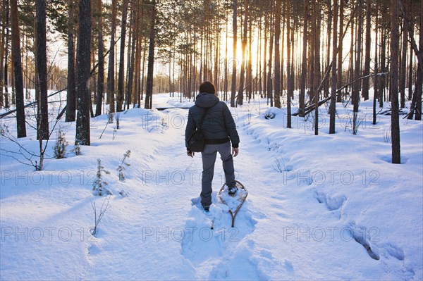 Mari man snowshoeing on snowy path
