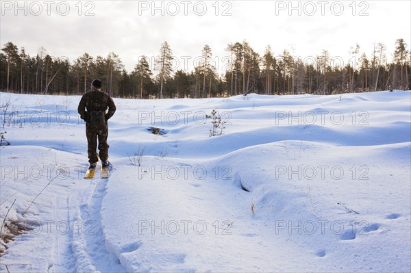 Caucasian man cross country skiing in snowy field