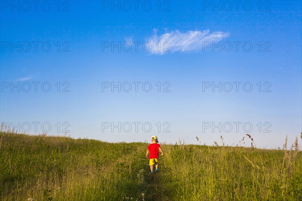Mari boy walking in rural field