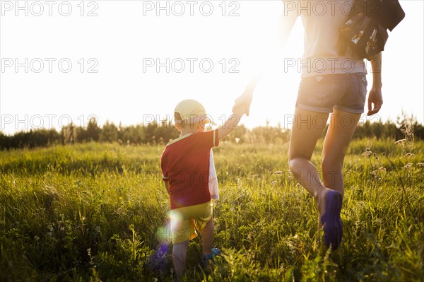 Mother and son walking in rural field