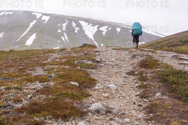 Mari backpacker walking on mountain path