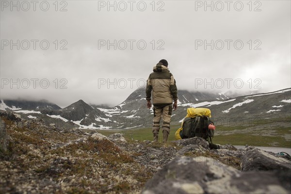 Mari backpacker standing in mountain field