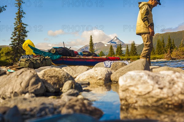 Mari hiker standing on rocks in remote river