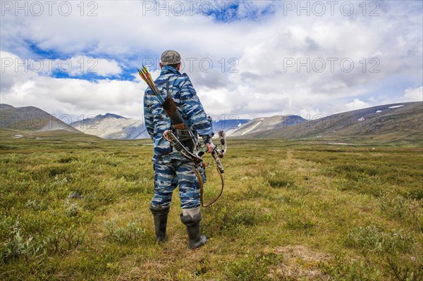 Mari hunter carrying crossbow in remote field