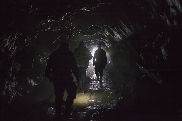 Men walking in dark cave