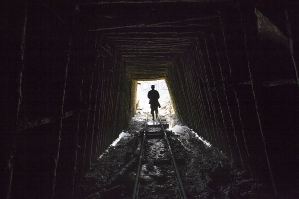 Mari man walking on tracks in mine