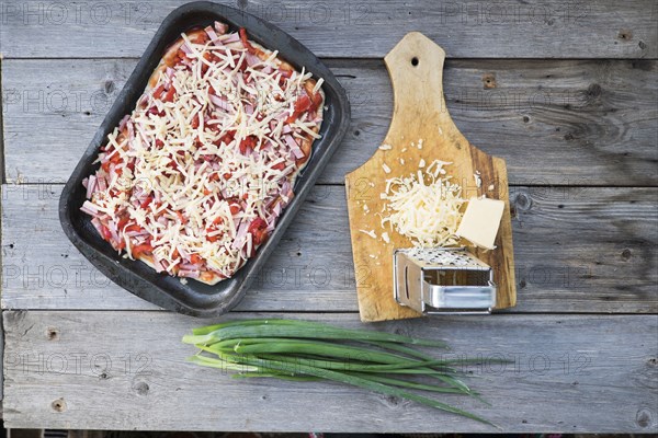 Cheese on cutting board near tray of pizza