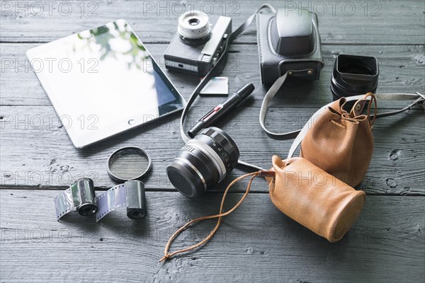 Film camera with accessories on table with digital tablet