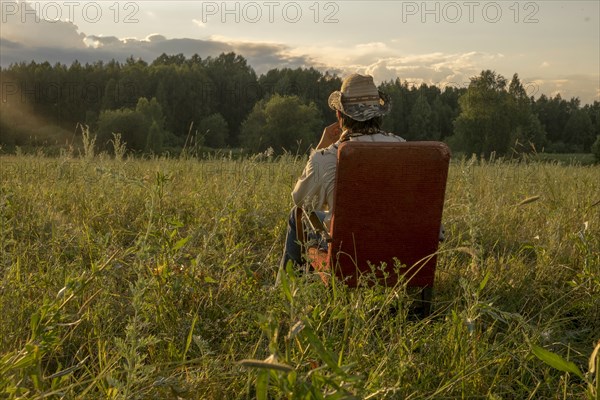 Mari man sitting on chair in field