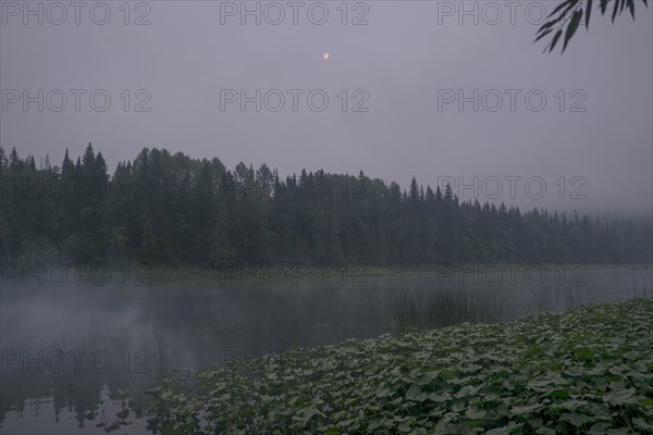 Moon over foggy river