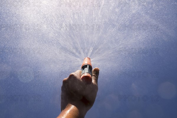 Mari boy spraying nozzle to blue sky