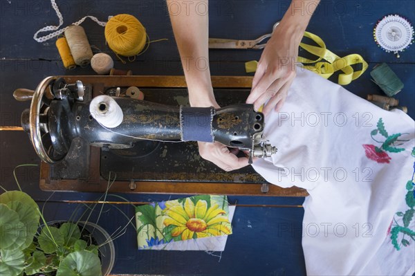 Hands of Caucasian woman using sewing machine