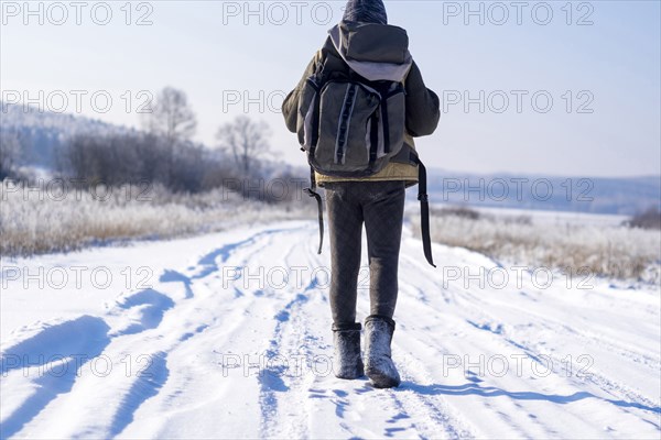 Caucasian man backpacking on snowy road