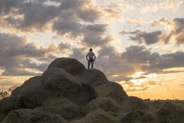 Caucasian man standing on rock pile at sunset