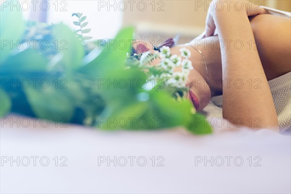 Face of Caucasian woman obscured by roses