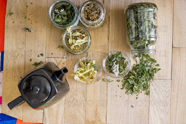 Teapot and tea leaves on table